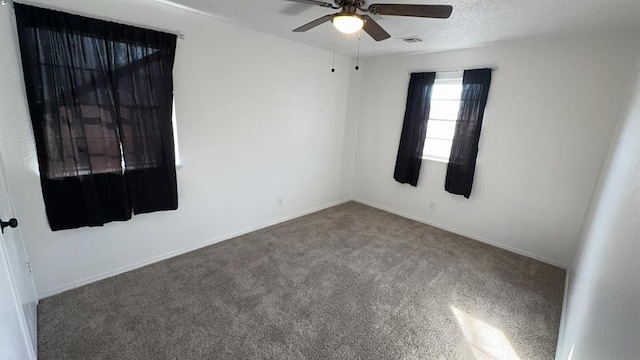 spare room featuring ceiling fan, a textured ceiling, and carpet