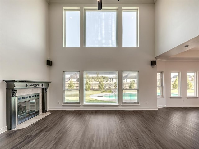 unfurnished living room with dark hardwood / wood-style floors, a healthy amount of sunlight, and a fireplace