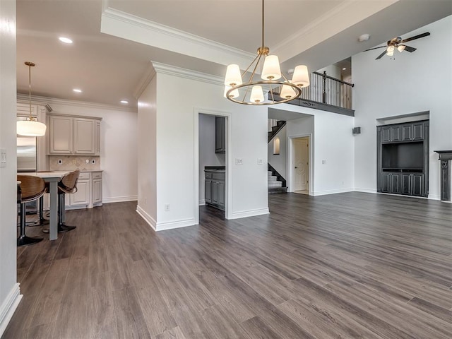 living room with ornamental molding, dark hardwood / wood-style floors, and ceiling fan with notable chandelier