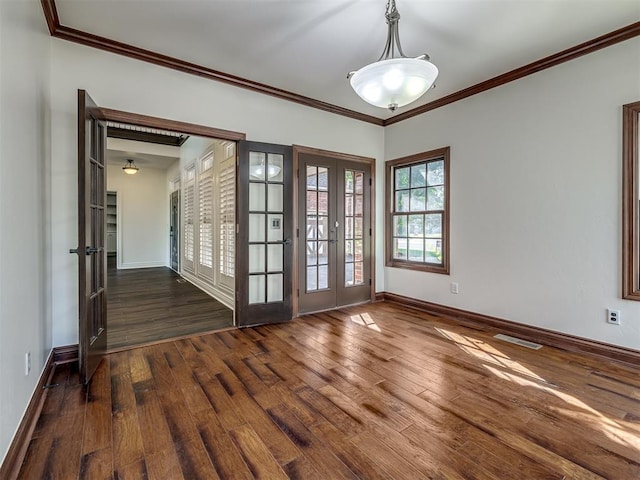 empty room featuring dark wood-type flooring, ornamental molding, and french doors