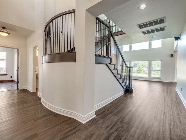 stairs featuring a high ceiling and hardwood / wood-style floors