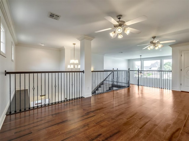 empty room with ornamental molding, dark hardwood / wood-style floors, and an inviting chandelier