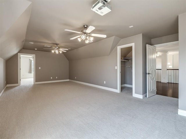 additional living space featuring ceiling fan, vaulted ceiling, and light carpet