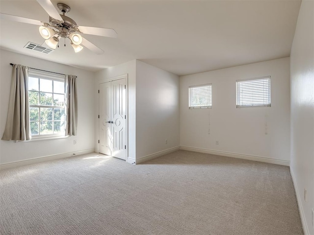 carpeted empty room featuring ceiling fan