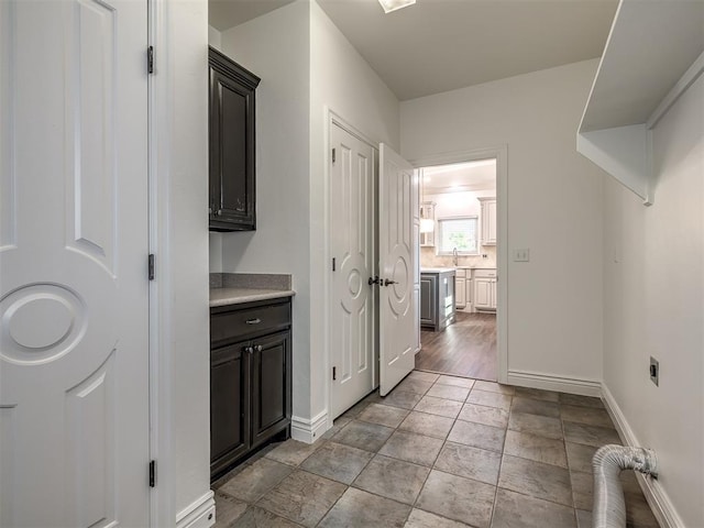 washroom featuring sink, light tile patterned flooring, cabinets, and hookup for an electric dryer