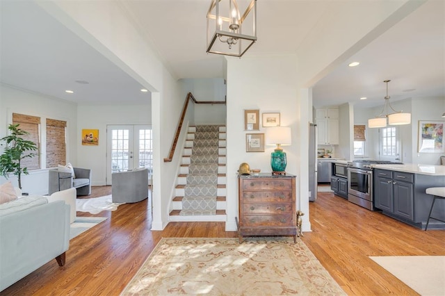 staircase with ornamental molding, hardwood / wood-style floors, and french doors