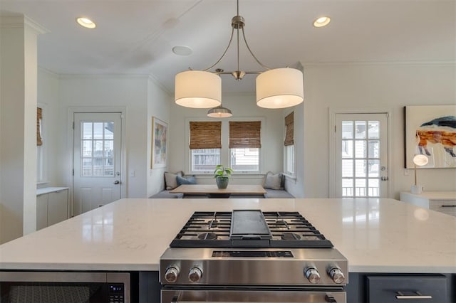 kitchen with stainless steel appliances, ornamental molding, a kitchen island, and decorative light fixtures