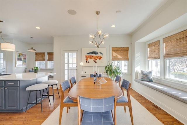 dining room featuring an inviting chandelier, crown molding, and light wood-type flooring