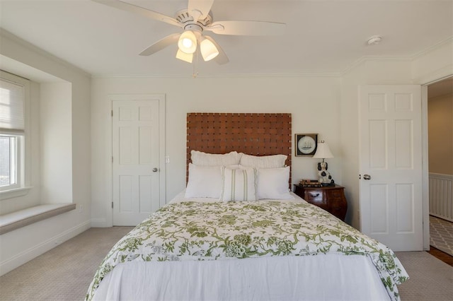 carpeted bedroom featuring ornamental molding and ceiling fan