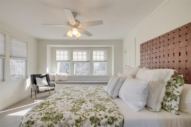 carpeted bedroom featuring ceiling fan and ornamental molding