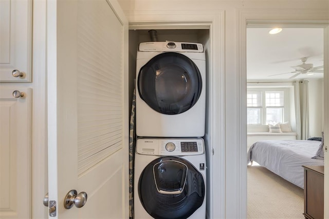 washroom featuring stacked washer / drying machine and ceiling fan