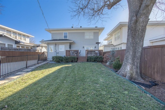 rear view of property featuring a wooden deck and a yard