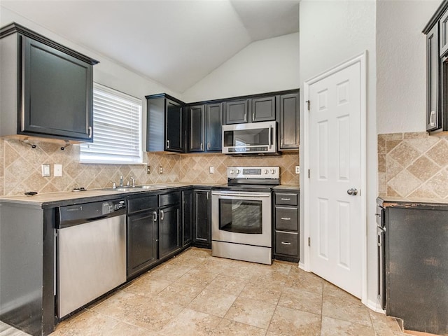 kitchen with sink, decorative backsplash, vaulted ceiling, and stainless steel appliances