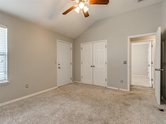 unfurnished bedroom with lofted ceiling, light carpet, a closet, and ceiling fan