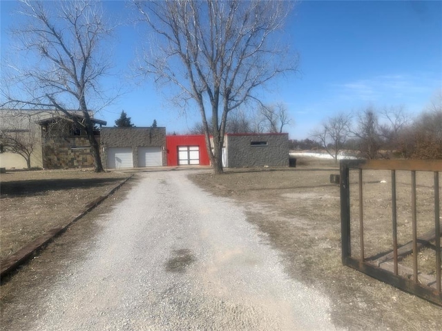 exterior space featuring dirt driveway and a garage