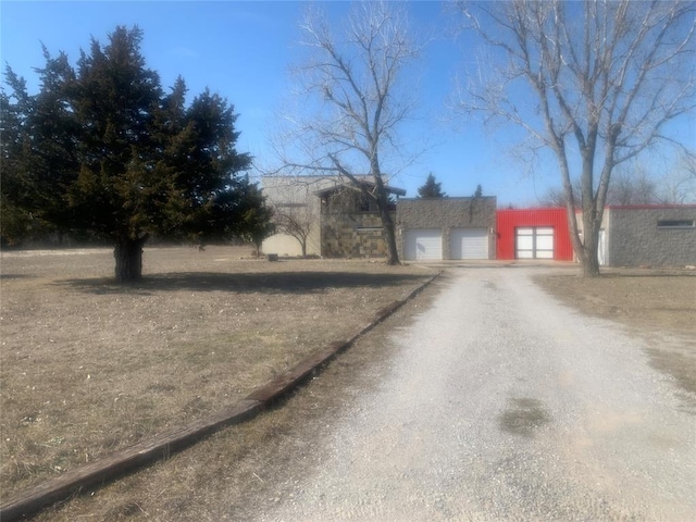 exterior space featuring a garage and dirt driveway