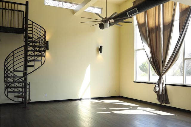 spare room with baseboards, stairway, a ceiling fan, and dark wood finished floors