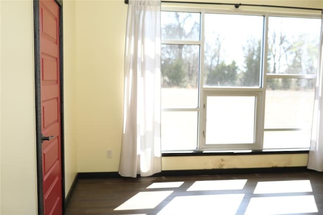 unfurnished room with dark wood finished floors and baseboards