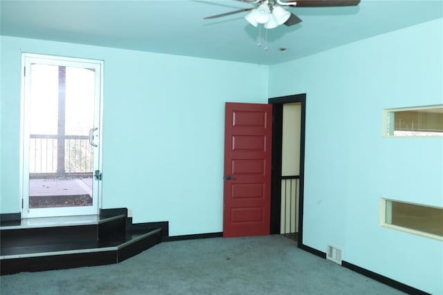 interior space with baseboards, visible vents, and a ceiling fan