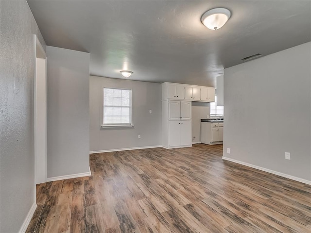 unfurnished living room featuring a healthy amount of sunlight and hardwood / wood-style floors