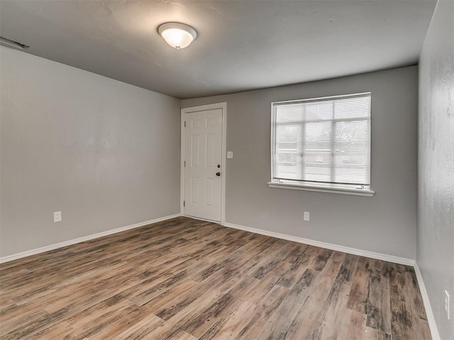 spare room featuring wood-type flooring