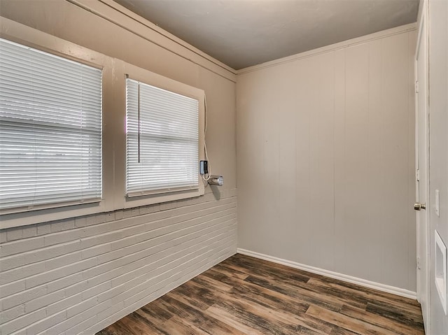 spare room with dark wood-type flooring and ornamental molding