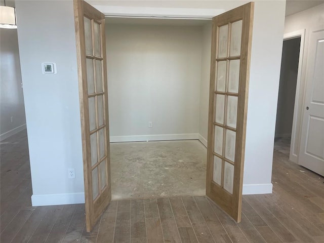 hall with dark wood-type flooring and french doors