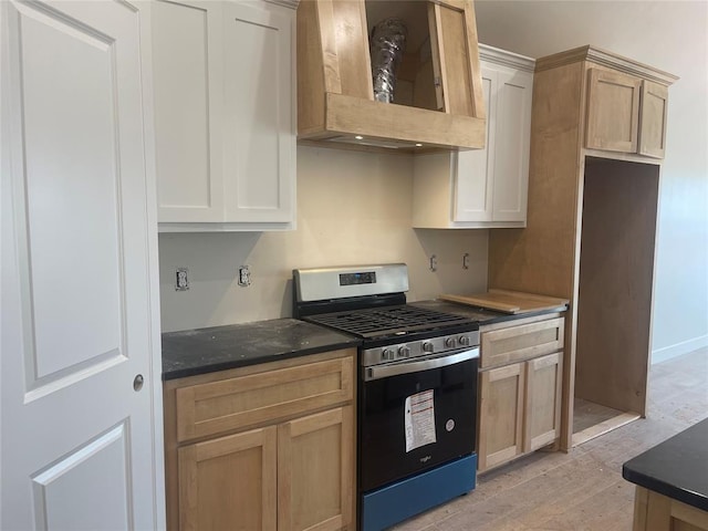 kitchen with stainless steel gas stove, light brown cabinetry, light hardwood / wood-style floors, and custom range hood