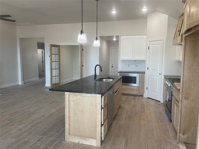 kitchen with pendant lighting, sink, dark wood-type flooring, gas stove, and an island with sink