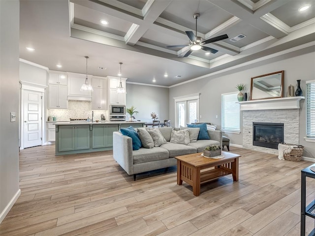 living room featuring beamed ceiling, ceiling fan, coffered ceiling, and light wood-type flooring