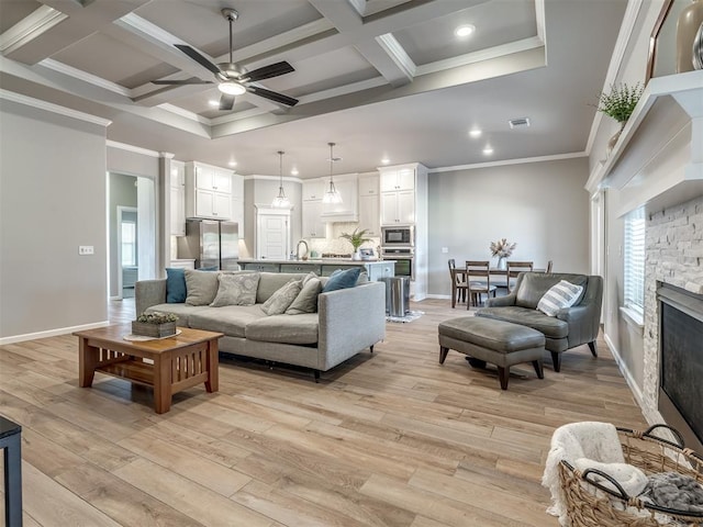 living room featuring crown molding, coffered ceiling, and light hardwood / wood-style floors