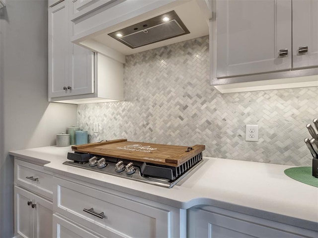 kitchen with white cabinetry, decorative backsplash, and premium range hood