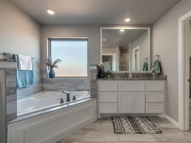 bathroom featuring vanity, a washtub, and toilet