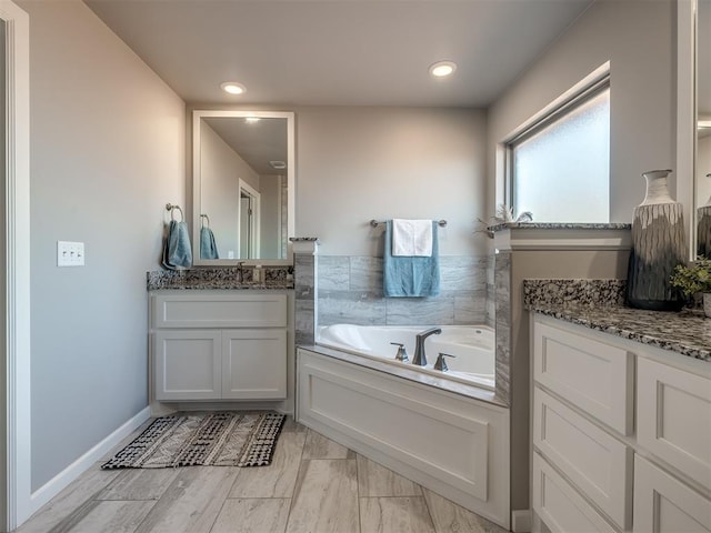 bathroom featuring vanity and a bath