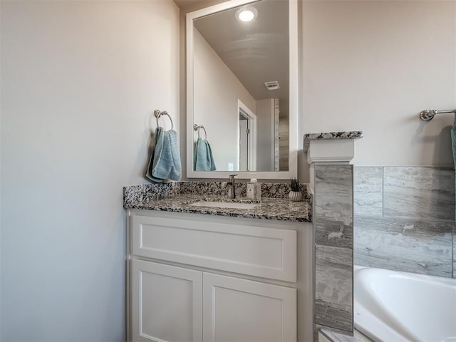 bathroom with vanity and a tub to relax in