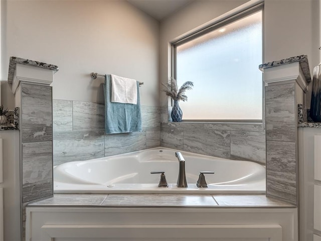 bathroom with a relaxing tiled tub