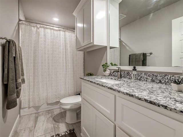 full bathroom with shower / tub combo with curtain, vanity, and toilet