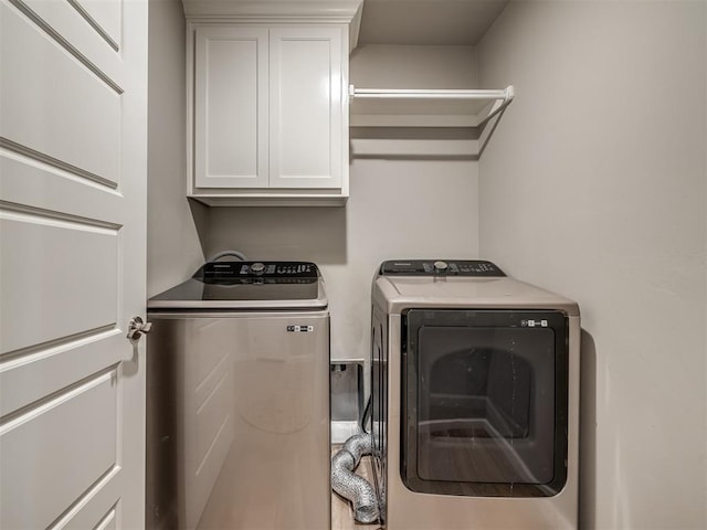 washroom featuring cabinets and washing machine and clothes dryer