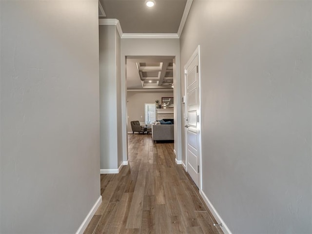 corridor featuring coffered ceiling, wood-type flooring, ornamental molding, and beamed ceiling