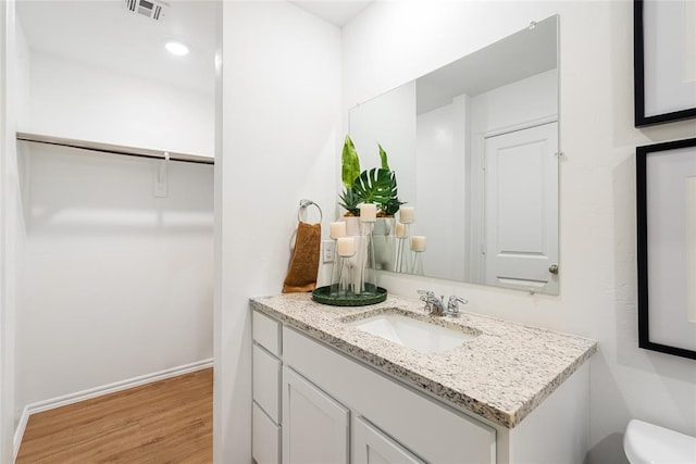 bathroom with vanity, toilet, and hardwood / wood-style floors