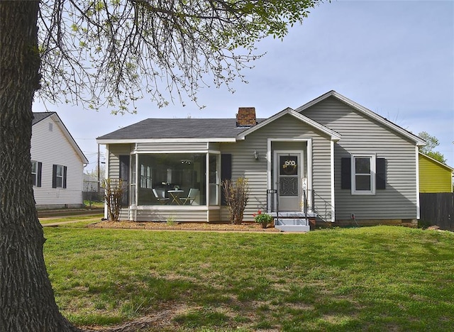 view of front of home with a sunroom and a front yard