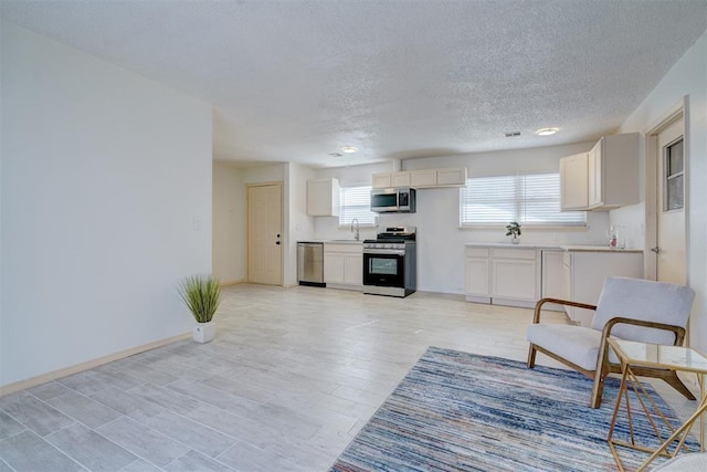 unfurnished living room featuring sink and a textured ceiling