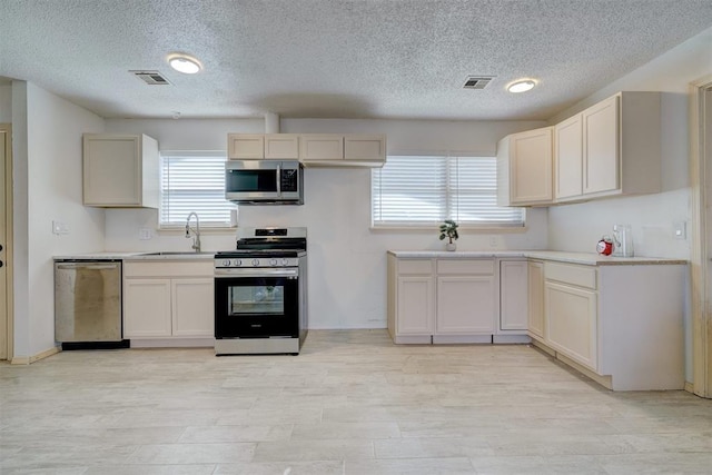 kitchen featuring appliances with stainless steel finishes, light hardwood / wood-style floors, and sink