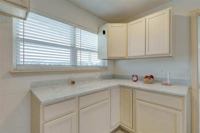 kitchen featuring white cabinetry and light stone counters