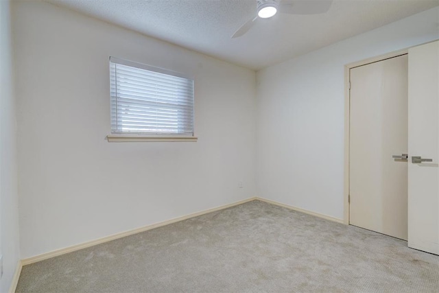 unfurnished room featuring ceiling fan and light carpet