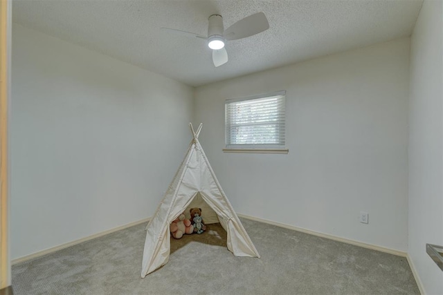 game room featuring ceiling fan, light carpet, and a textured ceiling