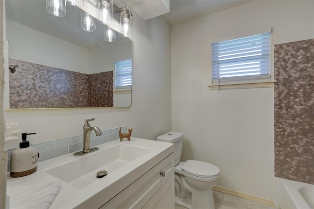 bathroom with vanity, a healthy amount of sunlight, and toilet