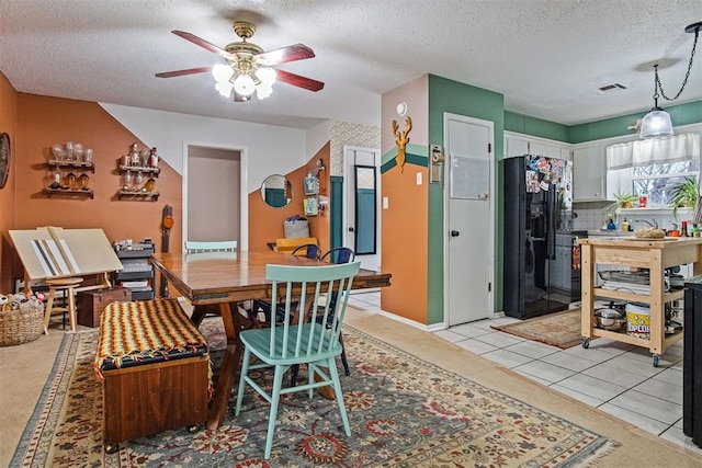 tiled dining area featuring ceiling fan and a textured ceiling