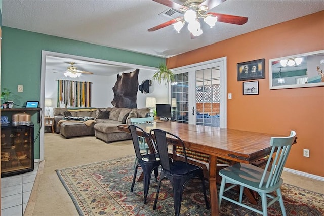 tiled dining space featuring ceiling fan and a textured ceiling