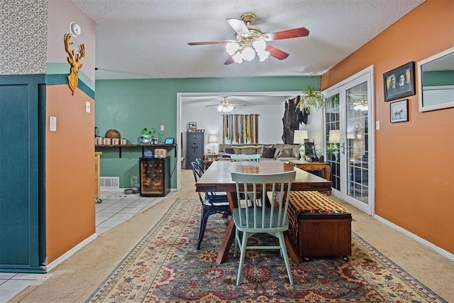 tiled dining room featuring ceiling fan and a textured ceiling